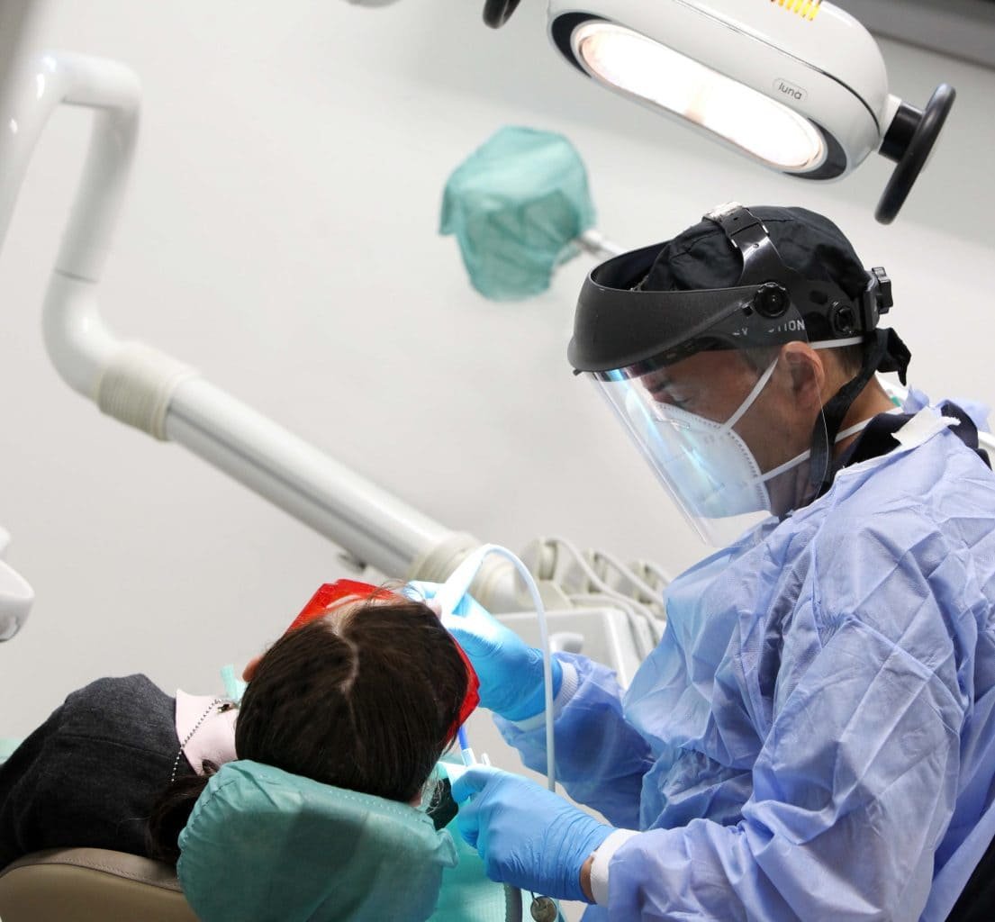 Un dentista effettua un intervento su un paziente