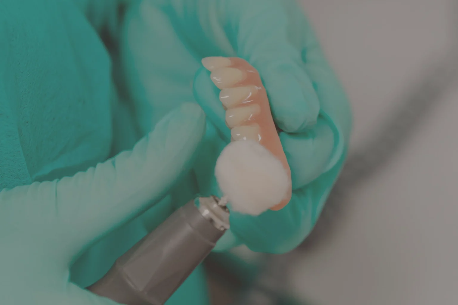 Dentista che effettua la lucidatura di una protesi mobile dentale per garantirne igiene e durata